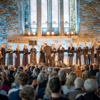 I Håkonshallen svævede Kirsten Flagstads (1895-1962) stemme atter gennem rummet – hentet frem fra gamle optagelser og omsluttet af 16 nulevende stemmer fra Edvard Grieg Vokalensemble og Valen Vokalensemble. © Helene Myksvoll